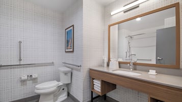 Un baño moderno con inodoro, lavamanos y ducha.