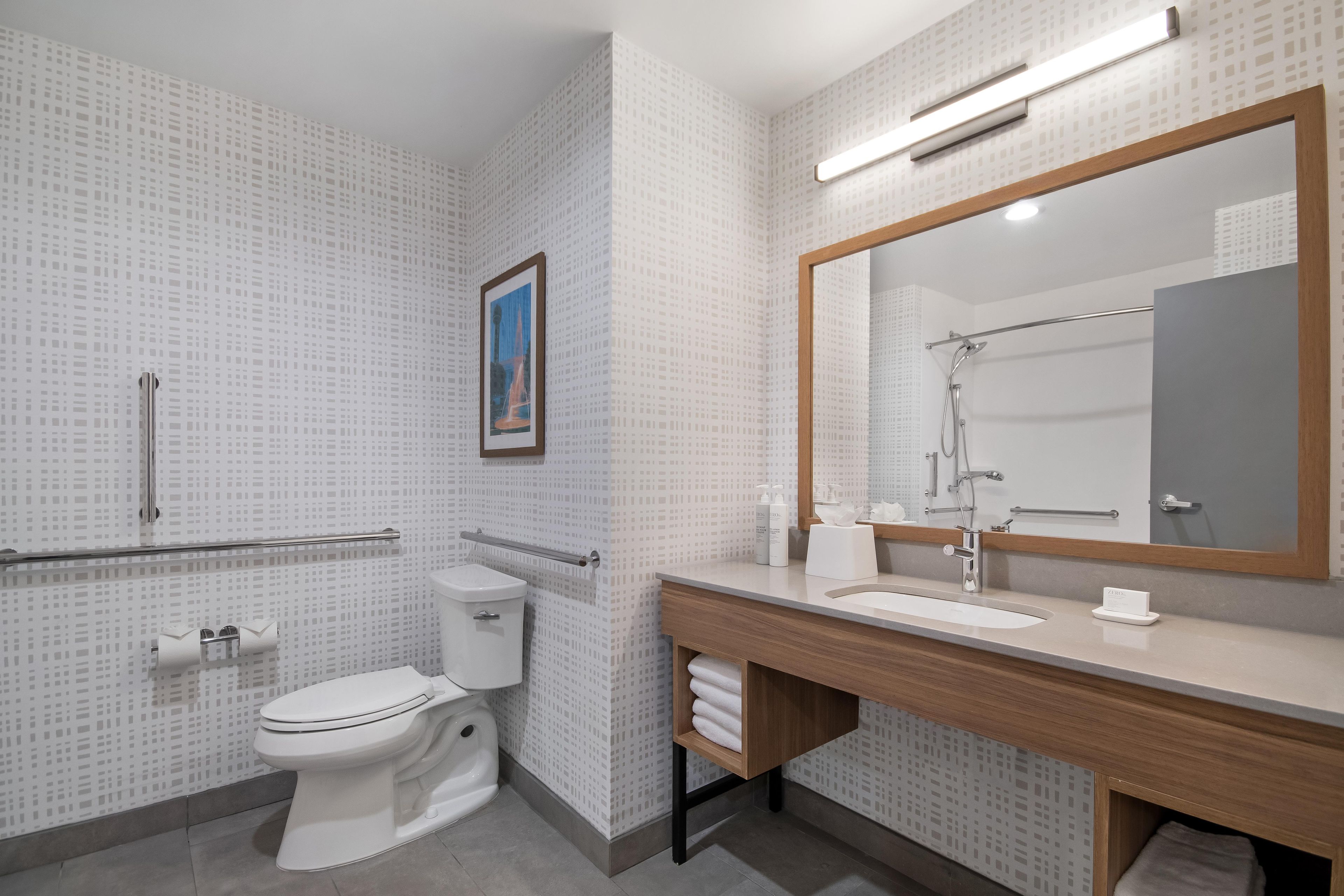 Een moderne badkamer met toilet, wastafel en douche.