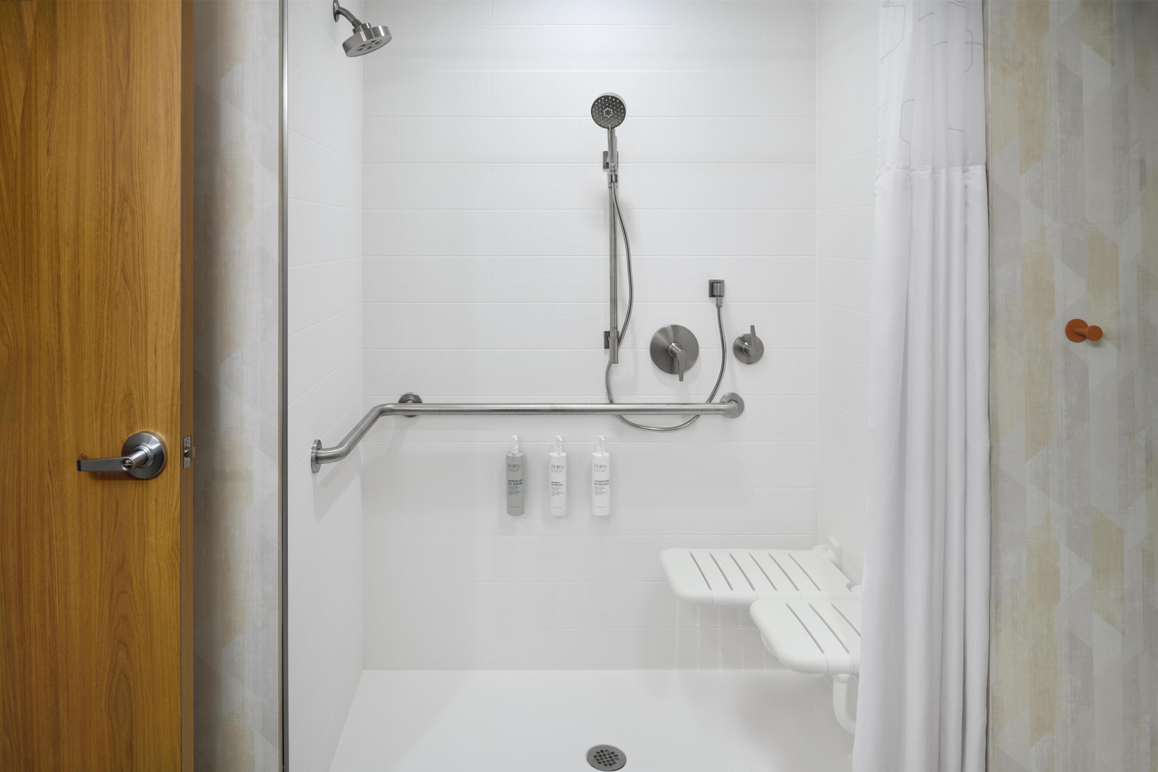 A shower with a handheld showerhead, a handheld showerhead, and a handheld showerhead.