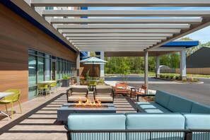 An outdoor patio with seating, a fire feature, and a covered area with a 'welcome' sign. - Hampton Inn By Hilton Lawrenceburg (Lawrenceburg)