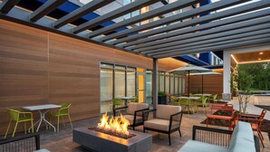 An outdoor patio with a fire feature, seating, and a covered area with tables and chairs. - Hampton Inn By Hilton Lawrenceburg (Lawrenceburg)