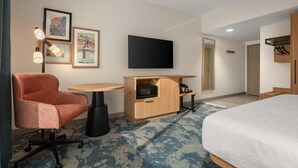 A hotel room with a bed, a desk with a flat-screen TV, a chair, a small table, and a microwave. - Hampton Inn By Hilton Lawrenceburg (Lawrenceburg)