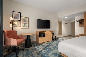 A hotel room with a bed, a desk with a flat-screen TV, a chair, a small table, and a microwave. - Hampton Inn By Hilton Lawrenceburg (Lawrenceburg)