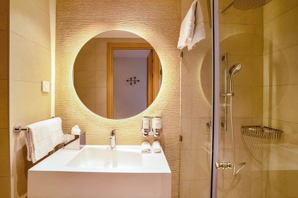 A modern bathroom with a large rectangular sink, a round mirror, and a glass-enclosed shower. - Hampton By Hilton Ben Guerir (Ben Guerir)