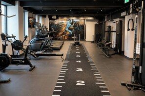 A gym with treadmills, weight machines, and a motivational mural. - Aloft by Marriott Manchester City Centre (Manchester)