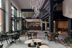 Un interior moderno con un mostrador de recepción, una zona de estar y una escalera.