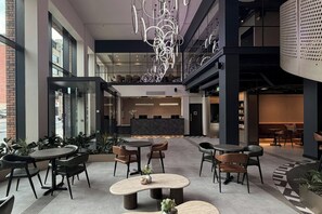 Ein modernes Interieur mit einer Rezeption, einer Sitzecke und einer Treppe.