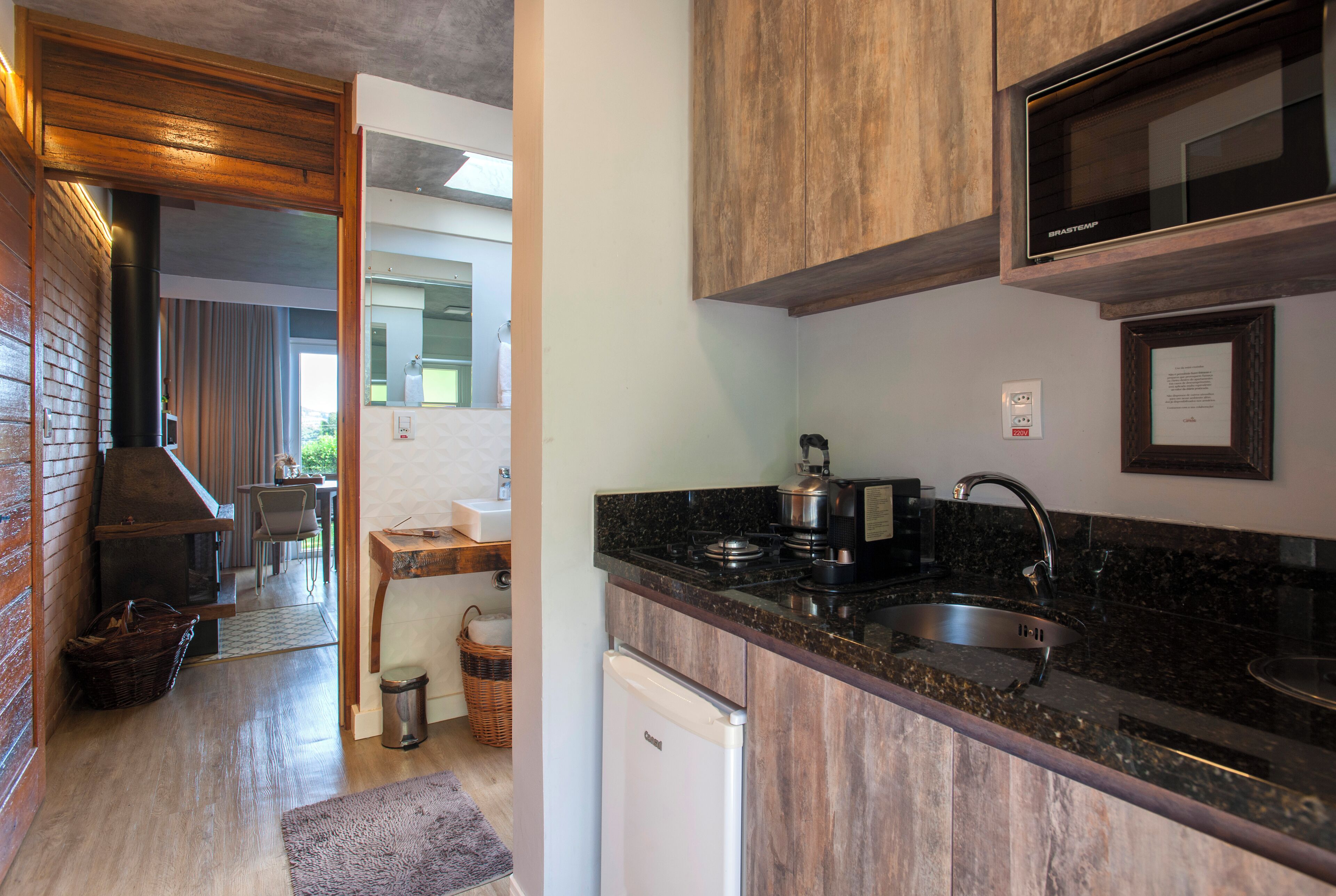 Una cocina moderna con horno integrado, pileta de acero inoxidable y muebles de madera.