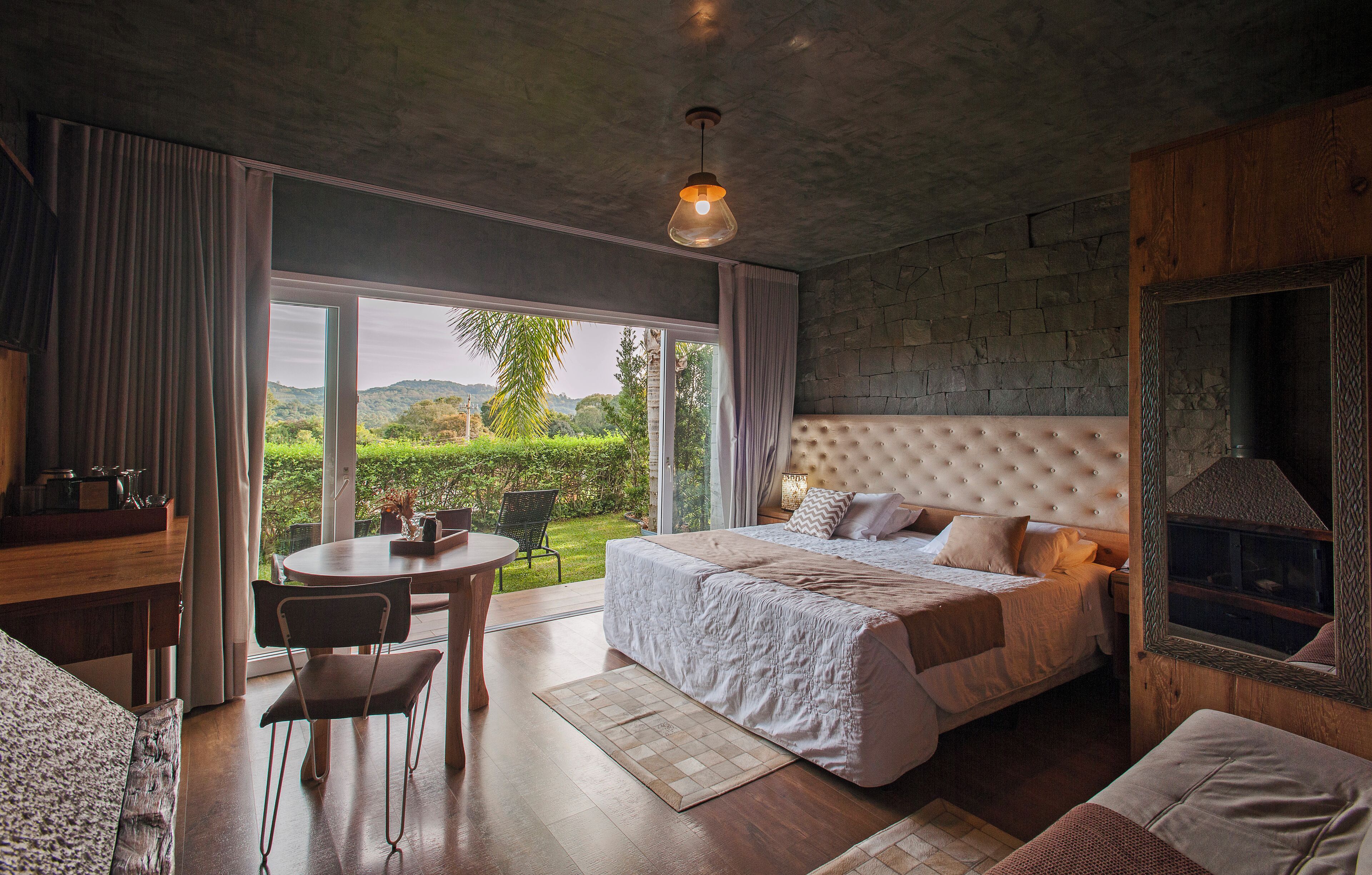Un dormitorio con una cama grande, un comedor y vistas al exterior.