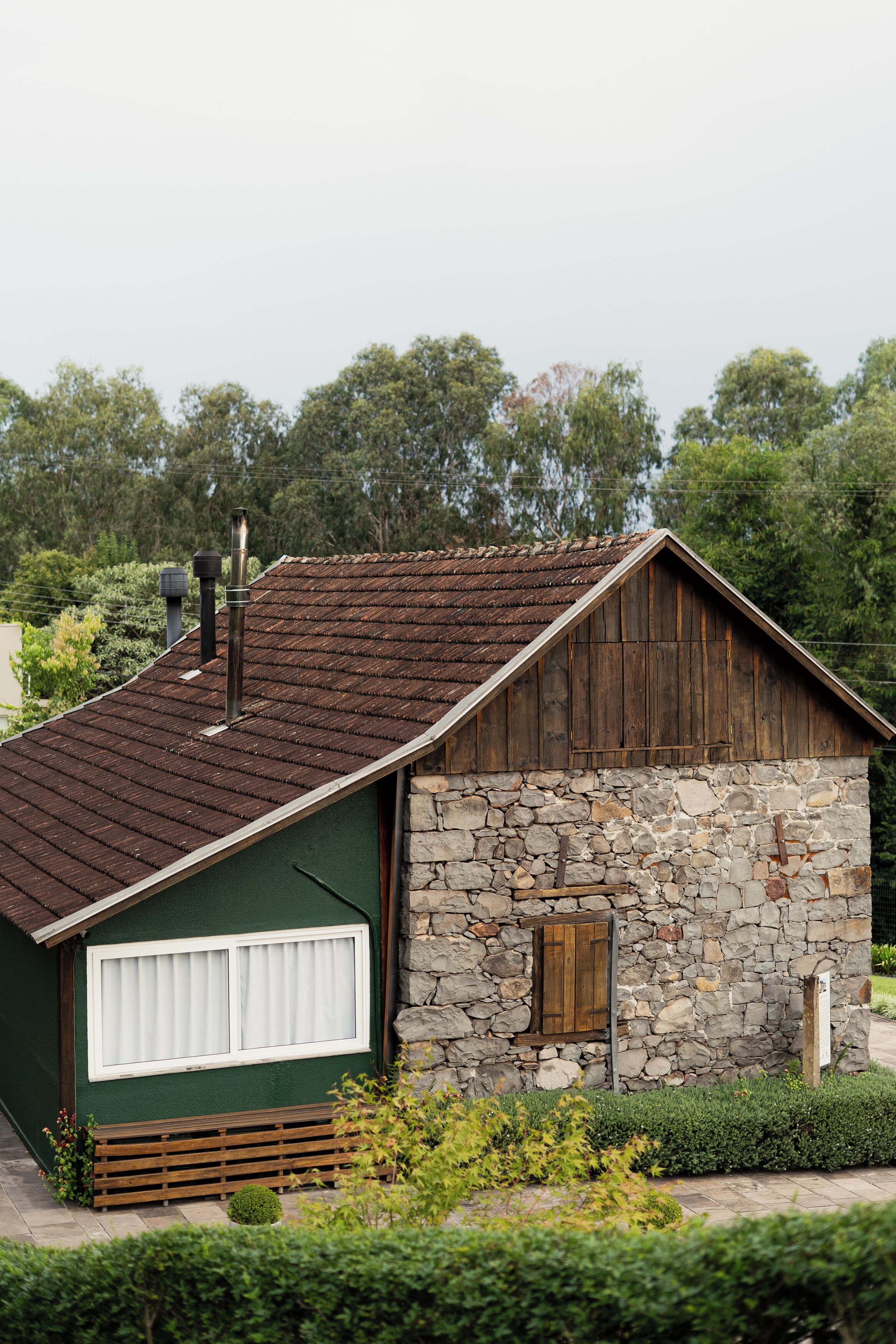 A rustic building with a stone wall and a wooden roof.