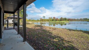 Un espacio al aire libre cubierto con vista a un lago y follaje otoñal.