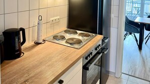 Eine moderne Küche mit einer schwarzen Dunstabzugshaube, einem eingebauten Backofen und einer Kaffeemaschine auf der Arbeitsfläche.