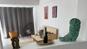 A modern living room with a sofa, a coffee table, and a unique green boot sculpture.