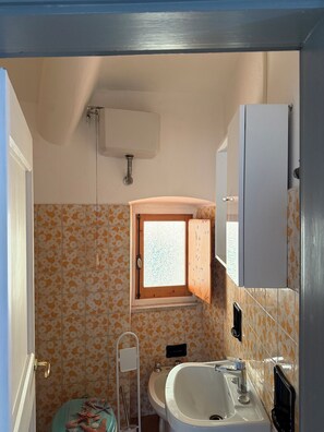 A bathroom with a toilet, sink, and window. - Villa Camelia: apartment with sea view (San Lorenzo della Costa)