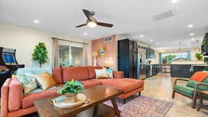 A modern living room with a sectional sofa, a coffee table, and a ceiling fan. - Resort Pool | Private Hot Tub | Close to Old Town (Scottsdale)