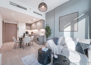 Een moderne woonkamer met een bank, salontafel en een eethoek met stoelen en een tafel.
