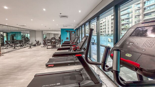 Et moderne fitnesscenter med løbebånd, styrkemaskiner og træningsbolde.