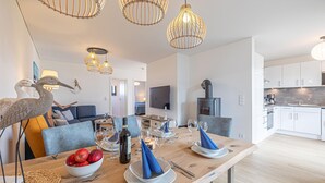 Una cocina moderna con armarios blancos, horno empotrado y una isla grande con encimera de madera.