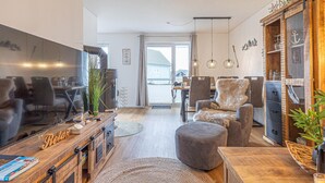 Una sala de estar moderna con chimenea, asientos cómodos y vistas a través de un amplio ventanal corredero.