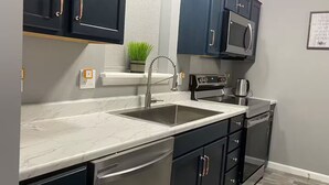 A modern kitchen with dark cabinets, a stainless steel sink, and a microwave. - Downtown Harrisburg close to Hershey PA-Sleeps 8 (Harrisburg)