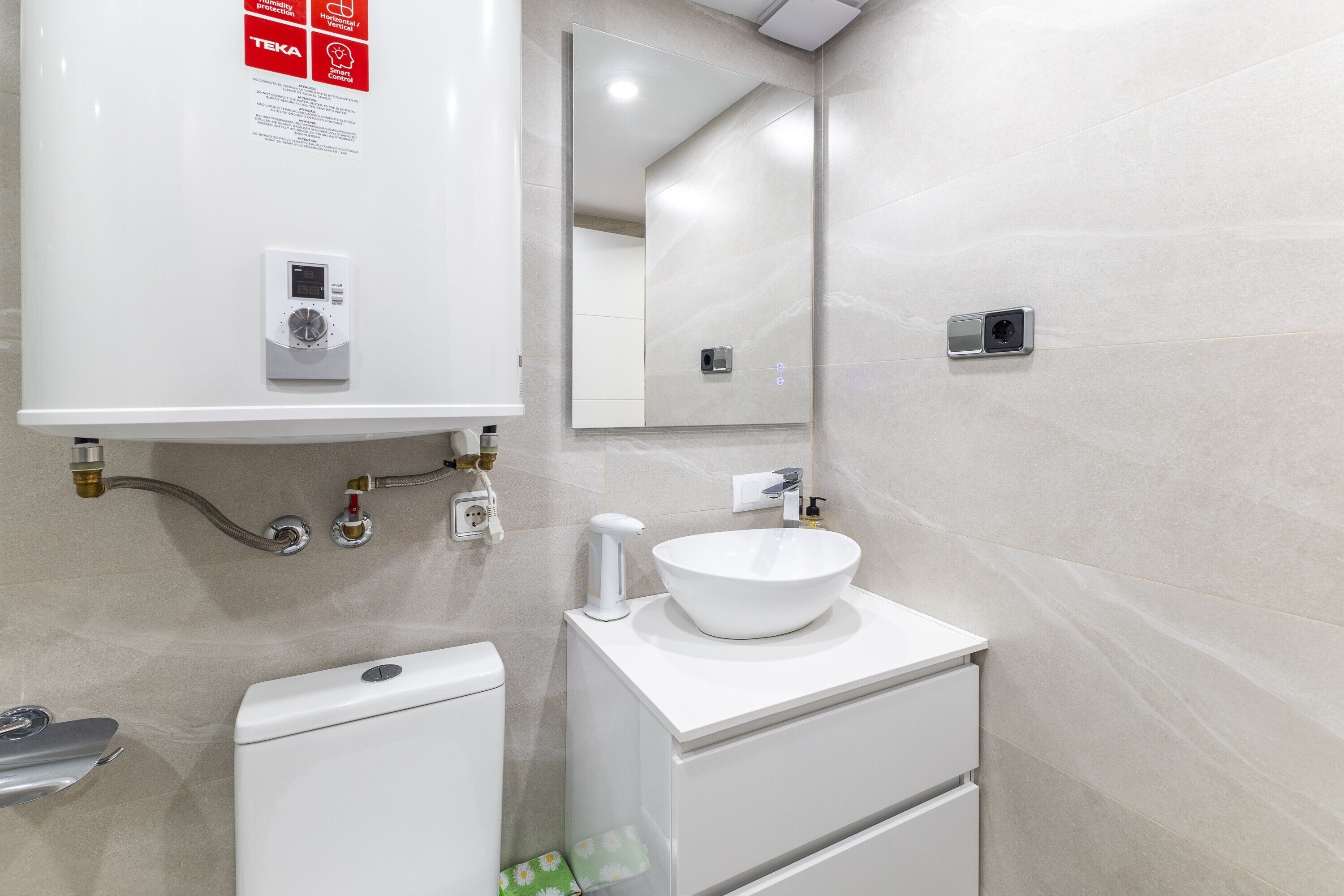 Une salle de bain moderne équipée de toilettes, d’un bidet et d’un lavabo.