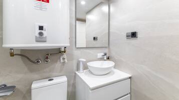 Une salle de bain moderne équipée de toilettes, d’un bidet et d’un lavabo.