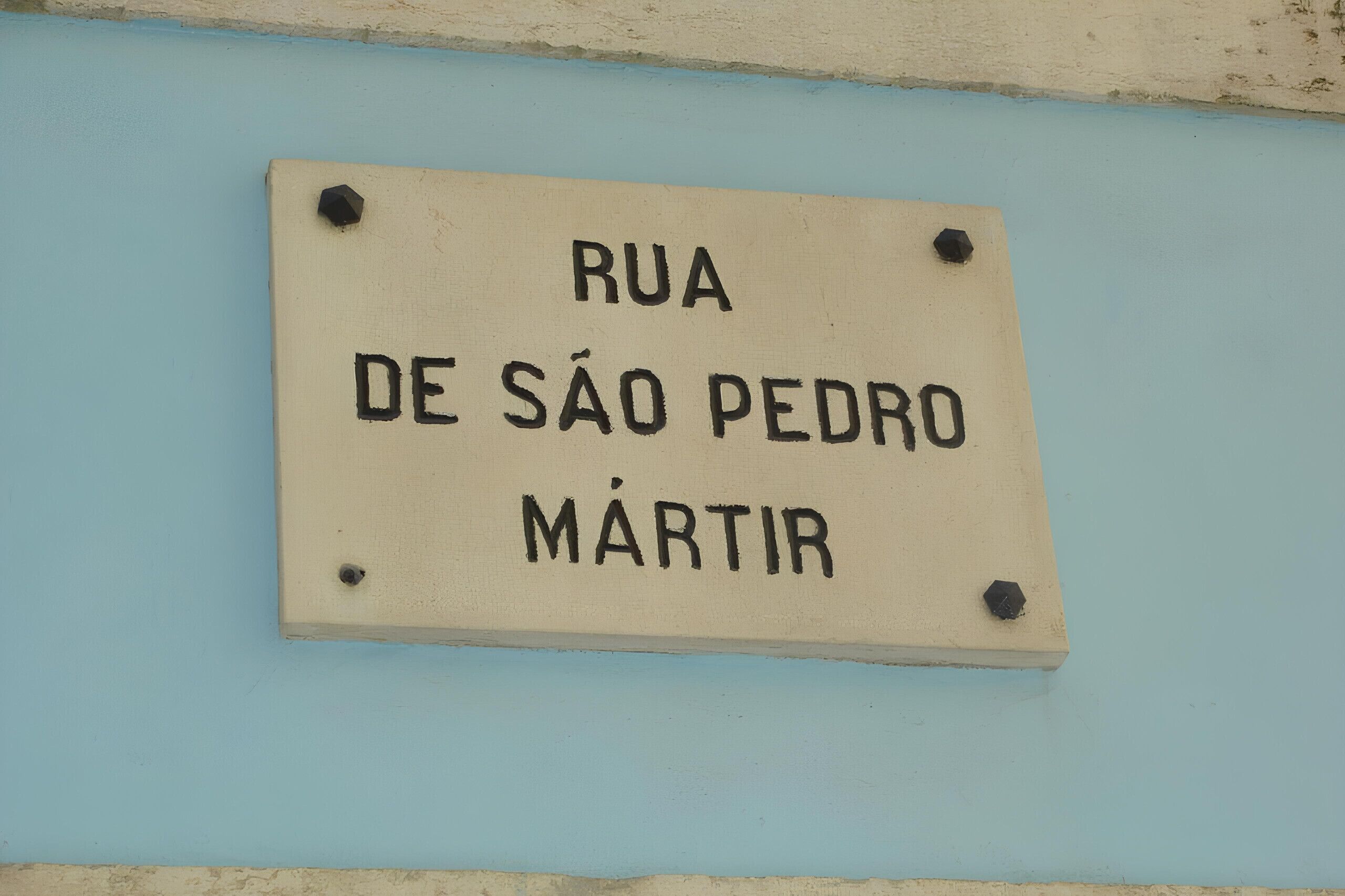 A sign with the text "Rua de São Pedro Mártir" mounted on a wall.