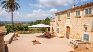 A stone building with a patio, outdoor seating, and a view of the landscape. - Beautiful home in Manacor with private swimming pool, can be inside or outside (Manacor)