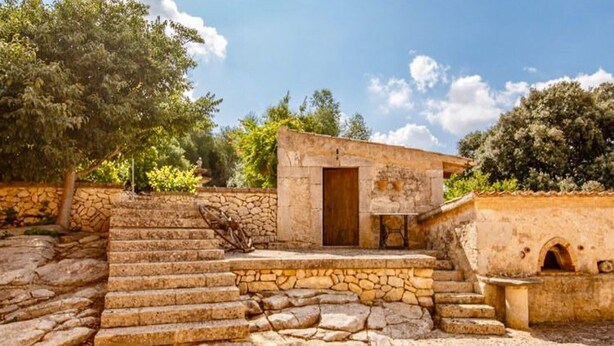 A stone staircase leading to a small building with a wooden door, surrounded by greenery and a clear sky. - Beautiful home in Manacor with private swimming pool, can be inside or outside (Manacor)