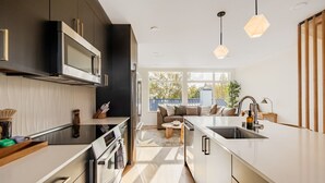A modern kitchen with a central island, built-in appliances, and pendant lighting. - NEW Queen Anne View Retreat | Sleeps 8 w/ A/C (Seattle)