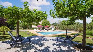 A swimming pool with lounge chairs and umbrellas, surrounded by trees and a grassy area. - Stunning home in Montignargues (Montignargues)