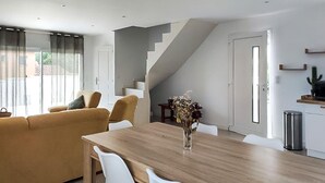 A modern living room with a sofa, a dining table, and a staircase. - Stunning home in Montignargues (Montignargues)