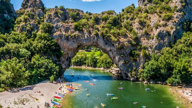 A natural rock arch over a river with boats and people on the shore. - Stunning home in Montignargues (Montignargues)