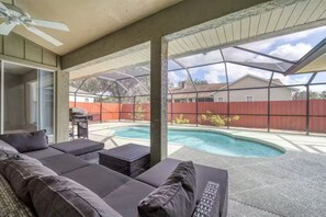 A covered patio with a pool, outdoor furniture, and a view of a house in the background. - Paradise Villa- Sarasota (Sarasota)