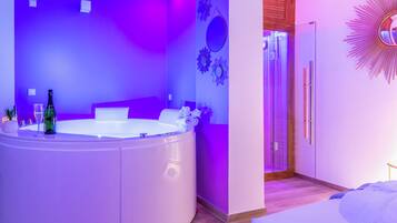 A modern bathroom with a large bathtub, a shower area, and a vanity with a mirror.