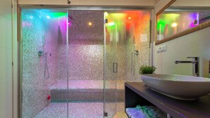 A modern bathroom with a glass-enclosed shower, a large white sink, and a mirror above the sink. - 4 Star Suite SPA  (Bologna)