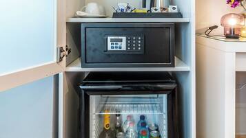 Eine kompakte Küche mit integriertem Kühlschrank, einer Kaffeemaschine und einem Wasserkocher auf der Arbeitsplatte.
