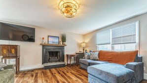 A living room with a fireplace, a sofa, a television, and a lamp.