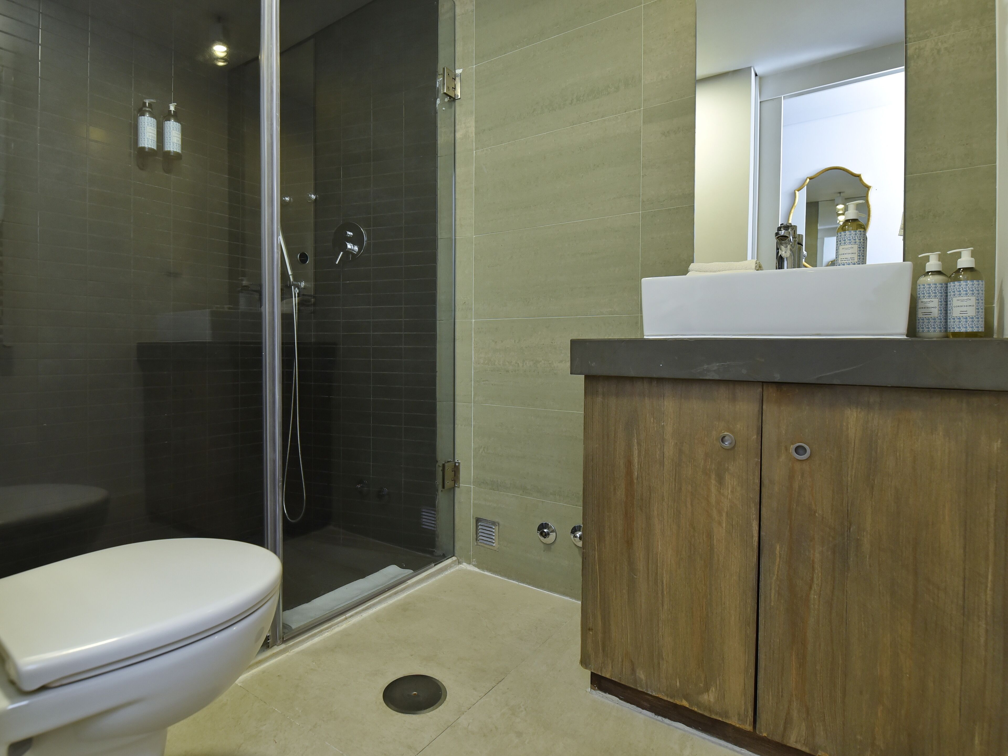 Ein Badezimmer mit Toilette, Dusche und Waschbecken mit Spiegel.
