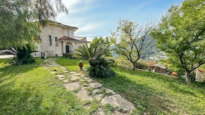 Una casa in pietra con un vialetto fiorito che conduce all'ingresso.