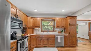 Une cuisine moderne avec des meubles en bois, des appareils électroménagers en acier inoxydable et une grande fenêtre.