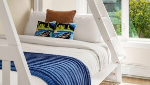 A bunk bed with a view of mountains through a large window.