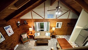 A cozy log cabin interior with a loft bedroom, a dining area, and a kitchen. - Lovely 2-Bedroom with Loft Condo at the Base of Snowshoe--a Perfect Getaway! (Snowshoe)