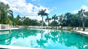A clear blue pool surrounded by palm trees and white railings. - 2-bedroom condo in Sarasota 1 1/2 miles from beautiful Siesta Key (Sarasota)