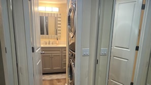 A hallway leading to a laundry area with a sink and cabinets. - 2-bedroom condo in Sarasota 1 1/2 miles from beautiful Siesta Key (Sarasota)