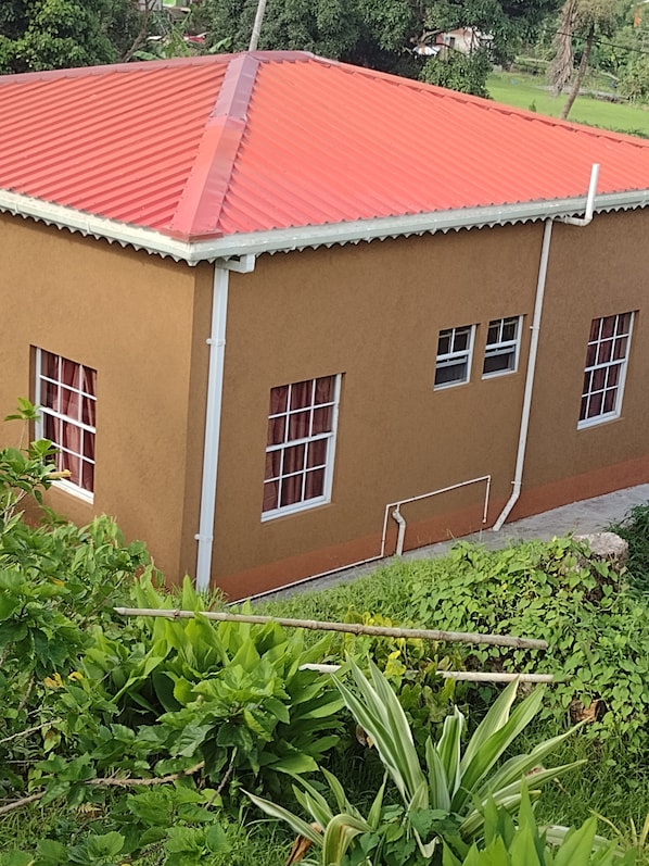 A two-story building with a red roof and multiple windows.