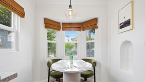 A dining area with a round table, two chairs, a bottle of water, and a framed picture on the wall. - Private Hot Tub, Mini-Golf, Firepit, BBQ, 10 Mins to Zoo & Balboa Park (San Diego)