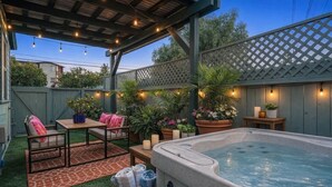 A backyard with a hot tub, outdoor seating, and string lights. - Private Hot Tub, Mini-Golf, Firepit, BBQ, 10 Mins to Zoo & Balboa Park (San Diego)