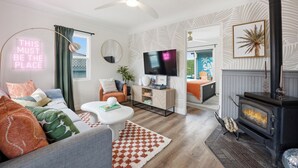 A modern living room with a fireplace, a television, and a neon sign. - Private Hot Tub, Mini-Golf, Firepit, BBQ, 10 Mins to Zoo & Balboa Park (San Diego)