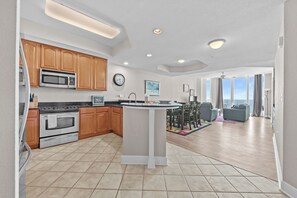 Una cocina moderna con armarios de madera, microondas integrado y una isla central.